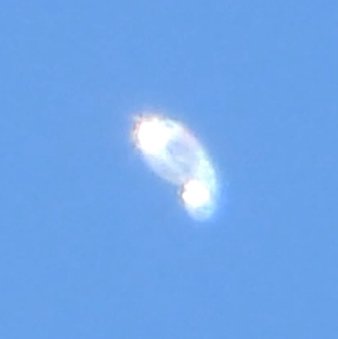 An oblique bright loop-like appearance against blue sky; a separate claimed observation.